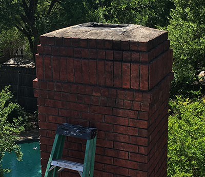 Chimney repairs-Chimney has no cap or crown coat-a ladder is standing beside the chimney