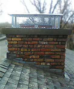 Stock photo of completed chimney repair-Black Velvet Chimney Completed installed chimney crown and cap with trees in the background