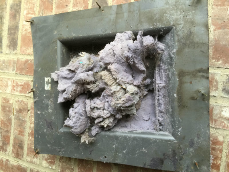 Blocked dryer vent exhaust overflowing with lint